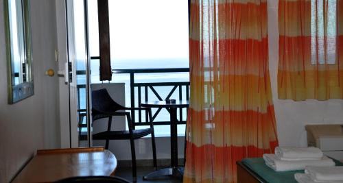 a room with a balcony with a table and a chair at Big Blue Studios in Kallithea Halkidikis