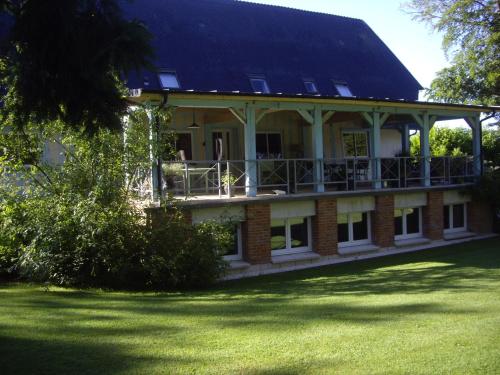 duży ceglany dom z dachem gambrel w obiekcie La Grange des Marettes w mieście Cléres