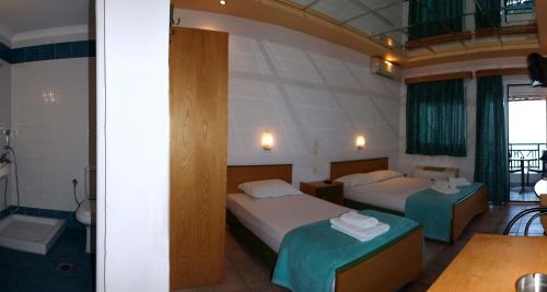 a hotel room with two beds and a table at Big Blue Studios in Kallithea Halkidikis