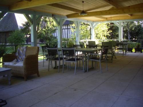 eine Terrasse mit Tischen und Stühlen unter einem Pavillon in der Unterkunft La Grange des Marettes in Cléres