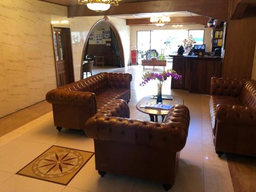 a lobby with two leather couches and a table at Sunny Garden in Antananarivo