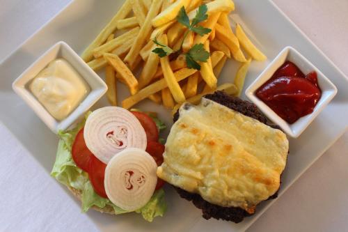 a plate of food with a sandwich and french fries at Tó Wellness Hotel in Bánk