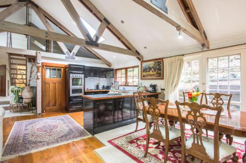 a kitchen with a wooden table and a dining room at The Stone on the Hill - 3 bedroom house in Kallista