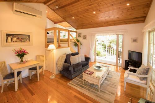 a living room with a couch and a table at Myers Creek Cascades Luxury Cottages in Healesville