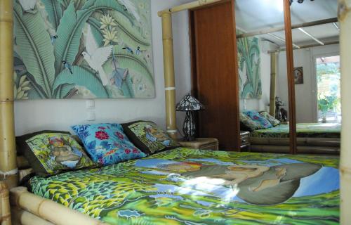 ein Schlafzimmer mit einem Bett und einem Wandgemälde in der Unterkunft Bambou House in Aix-en-Provence