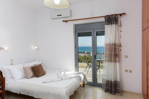 a bedroom with a bed and a view of the ocean at Coral Sea Studio in Kókkinos Pírgos