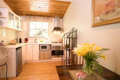 a kitchen with a vase of flowers on a table at Myers Creek Cascades Luxury Cottages in Healesville