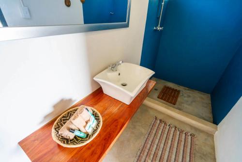 a bathroom with a white sink and a wooden floor at Caprivi Mutoya Lodge and Campsite in Katima Mulilo