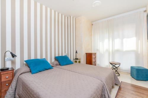1 dormitorio con 2 camas y almohadas azules en Turistic Home 4-Attic, en Málaga