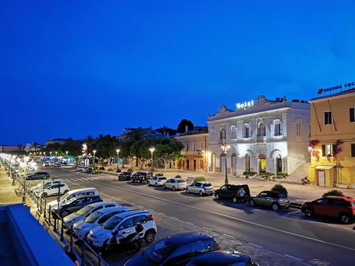 a city street with cars parked in a parking lot at Hotel Hieracon in Carloforte