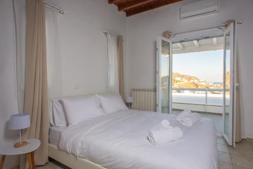 1 dormitorio con 1 cama y vistas al océano en The Corfos Hills House en Ornos