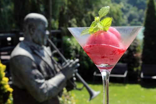 a drink with a strawberry in front of a statue at Tó Wellness Hotel in Bánk