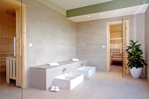 a bathroom with a sink and two toilets in it at Steigenberger Parkhotel Braunschweig in Braunschweig