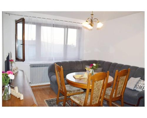 - un salon avec une table et un canapé dans l'établissement Apartmani Baljak, à Livno