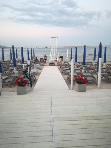a dock with chairs and a life guard stand on the beach at La Dolce Vista - B&B di Charme in Manfredonia