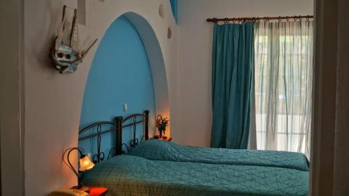 a bedroom with two beds with an arched window at Liogerma in Adamantas