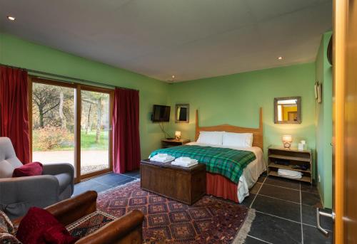 um quarto com paredes verdes, uma cama e um sofá em Powdermills B & B em Inveraray