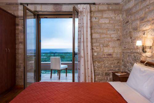 a bedroom with a bed and a view of the ocean at Enastron Villas in Kyparissia