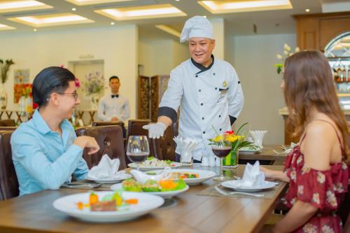 een chef-kok aan een tafel in een restaurant bij Westlake Hotel & Resort Vinh Phuc in Yen