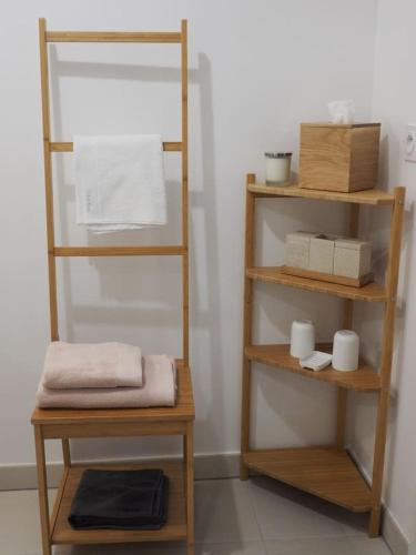 Cette chambre dispose d'étagères en bois et de serviettes. dans l'établissement La Londe La Mer : appartement proche plages & vue superbe sur les îles d'or, à La Londe-les-Maures