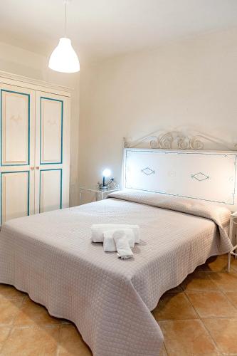 a bedroom with a large bed with two towels on it at Stella Marina Budoni in Budoni