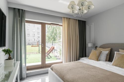 a bedroom with a bed and a large window at Queen in Gdynia