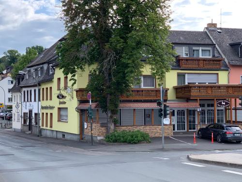 ein gelbes Gebäude an der Ecke einer Straße in der Unterkunft zum weißen Ross in Limburg an der Lahn