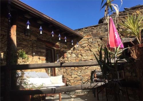 a patio with a bench and a stone building at Portugal Mountain Splendour - Xisto village in Tarrastal