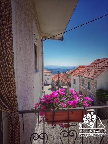 a balcony with a flower box with pink flowers at Casa Celeste in Castro Daire