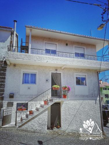 a white building with stairs and flowers on it at Casa Celeste in Castro Daire