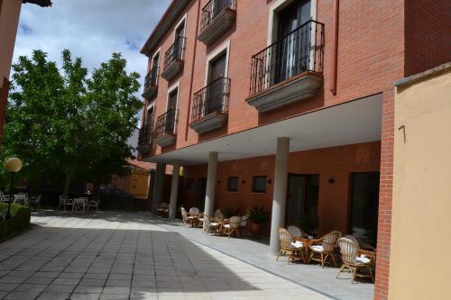 an empty courtyard with tables and chairs next to a building at Hotel Villegas in Valencia de Don Juan