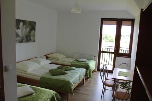 a bedroom with two beds and a balcony at Albatros in Gąski