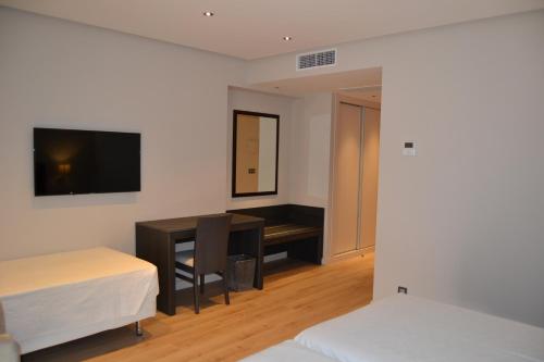 Hotel Villegas في فالنسيا دي دون خوان: غرفة نوم مع مكتب وسرير ومكتب