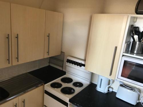 a small kitchen with a stove and a microwave at The Kathrene in Fleetwood