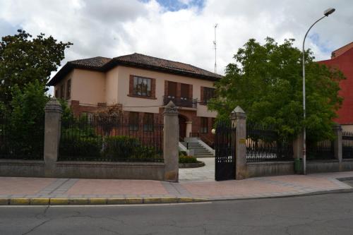 a house with a gate in front of a building at Hotel Villegas in Valencia de Don Juan