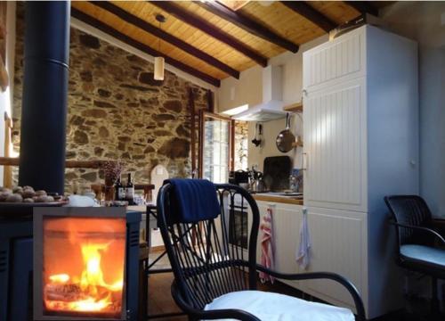 a living room with a fireplace in a kitchen at Portugal Mountain Splendour - Xisto village in Tarrastal