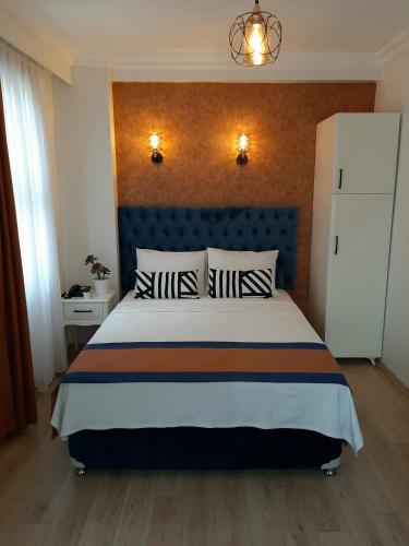 een slaapkamer met een groot bed met een blauw hoofdeinde bij Hotel Nova in Istanbul