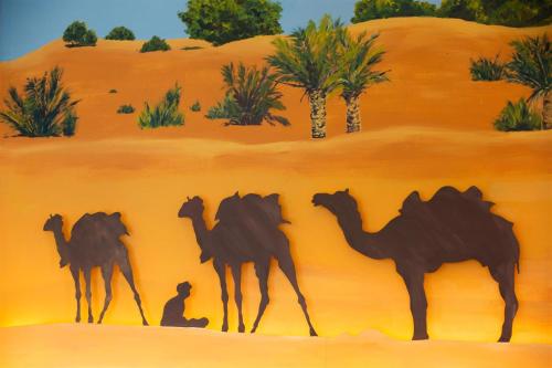 a painting of a man and four camels in the desert at Alfahad Hotel in Hat Yai