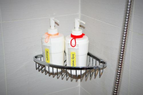 two white bottles on a rack on a bathroom wall at ACQUA Private Residences 1BR Condo in the heart of downtown Makati & Mandaluyong in Manila