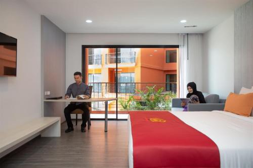 a man and woman sitting at a table in a hotel room at Alfahad Hotel in Hat Yai