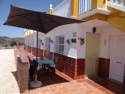 a table with an umbrella on the side of a building at B&B Casa Sarandy - Casita Mayo in Almogía