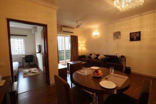 a living room with a table and a couch at Crest Executive Suites, Whitefield in Bengaluru
