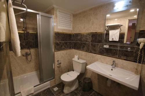 a bathroom with a toilet and a sink and a shower at Aykut Palace Otel in İskenderun