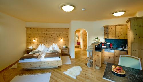 a bedroom with a bed and a kitchen at Grizzly Sport & Motorrad Resort in Sankt Margarethen im Lungau