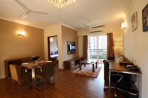 a living room with a table and a dining room at Crest Executive Suites, Whitefield in Bengaluru