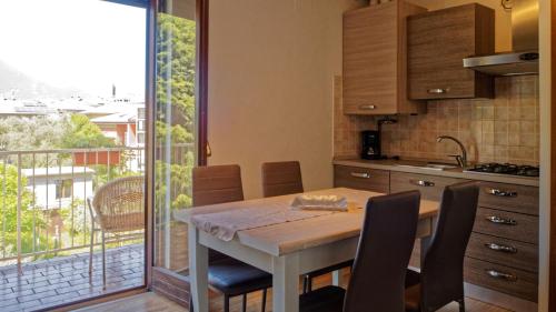una cucina con tavolo e sedie e un balcone di Residence Royal House a Riva del Garda