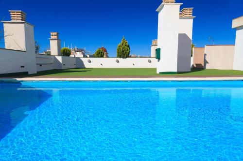 a swimming pool in front of a house at UHC Sol i Mar Family Complex in Salou