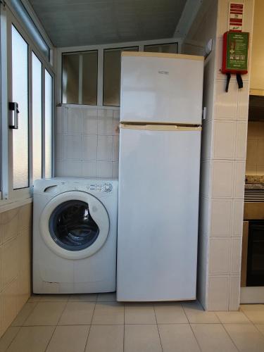 a white refrigerator and a washing machine in a kitchen at Ninho Jardim do Morro in Vila Nova de Gaia