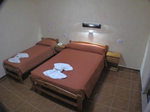 two beds in a hotel room with towels on them at Hotel Los Cedros in Buenos Aires