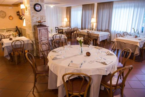 un comedor con mesas y sillas con manteles blancos en Hotel Iris, en Pescasseroli